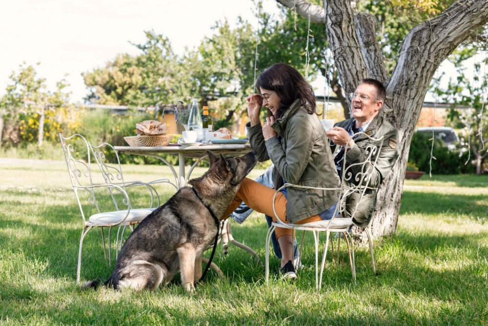 happy family with dog having breakfast in the garden