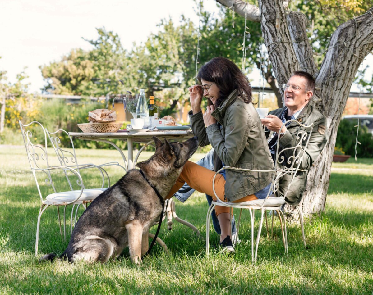 happy family with dog having breakfast in the garden