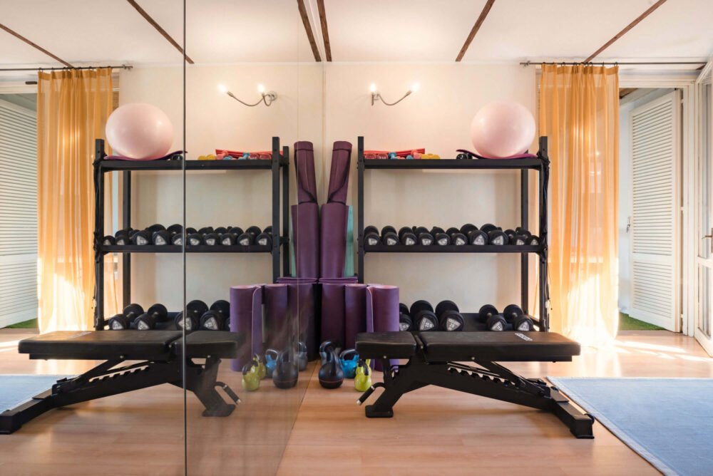gym equipped with barbells, yoga mat and kettlebell