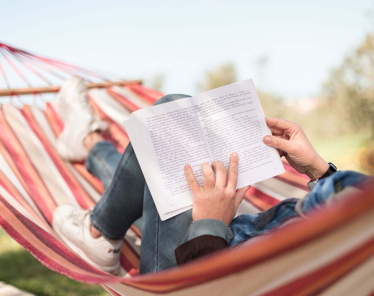 woman relaxing on the hammock with a book at podere l'agave San Vincenzo