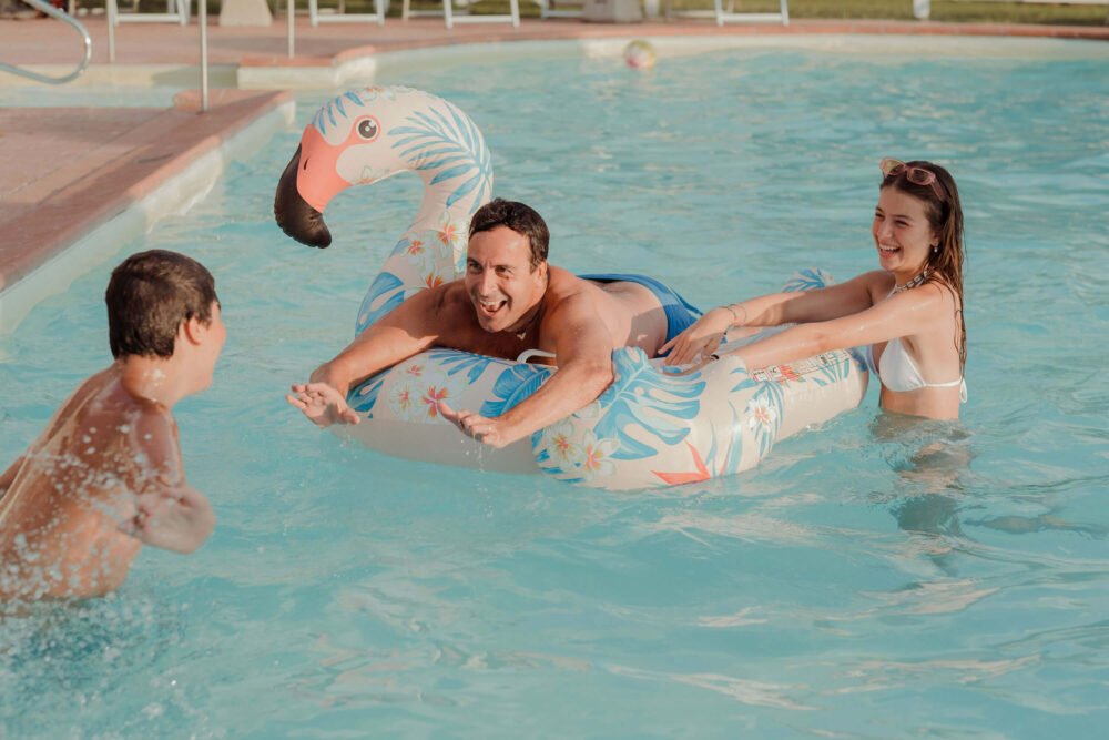family playing by the pool at podere l'agave San Vincenzo