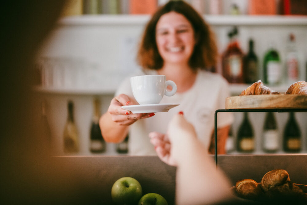 staff che serve cappuccino al bar